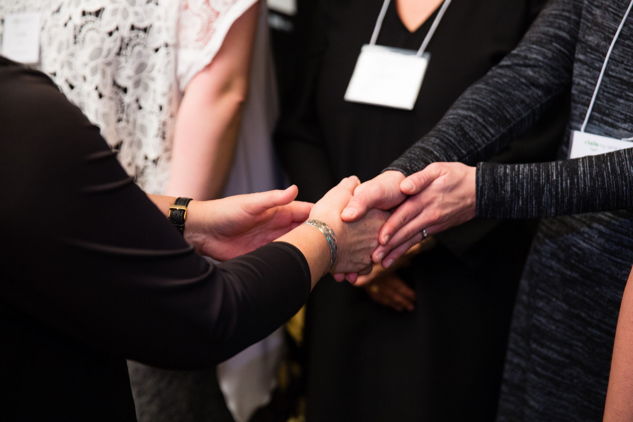 A close up of people shaking hands at the BC Quality Forum