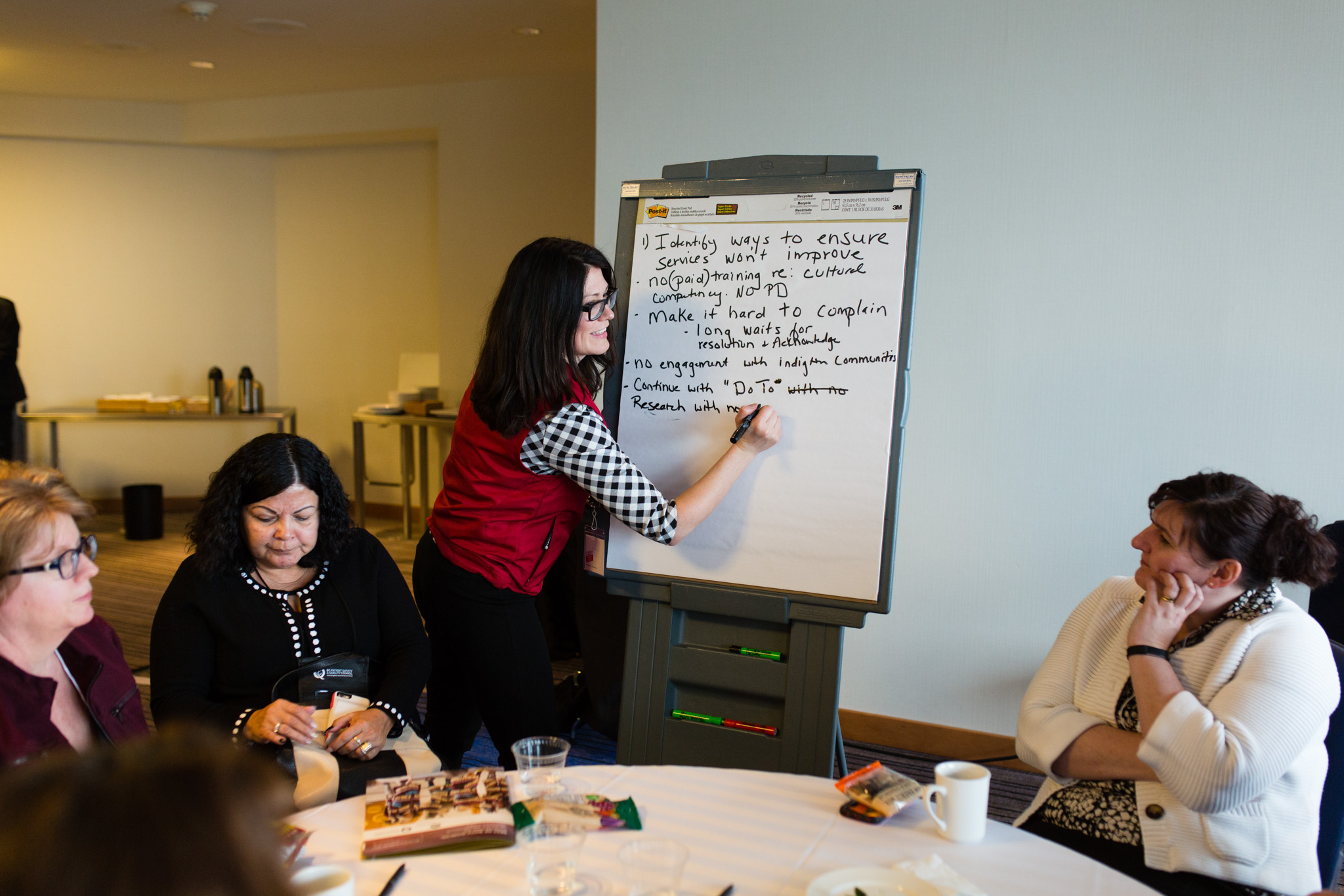 A woman writes on a whiteboard at the BC Quality Forum.
